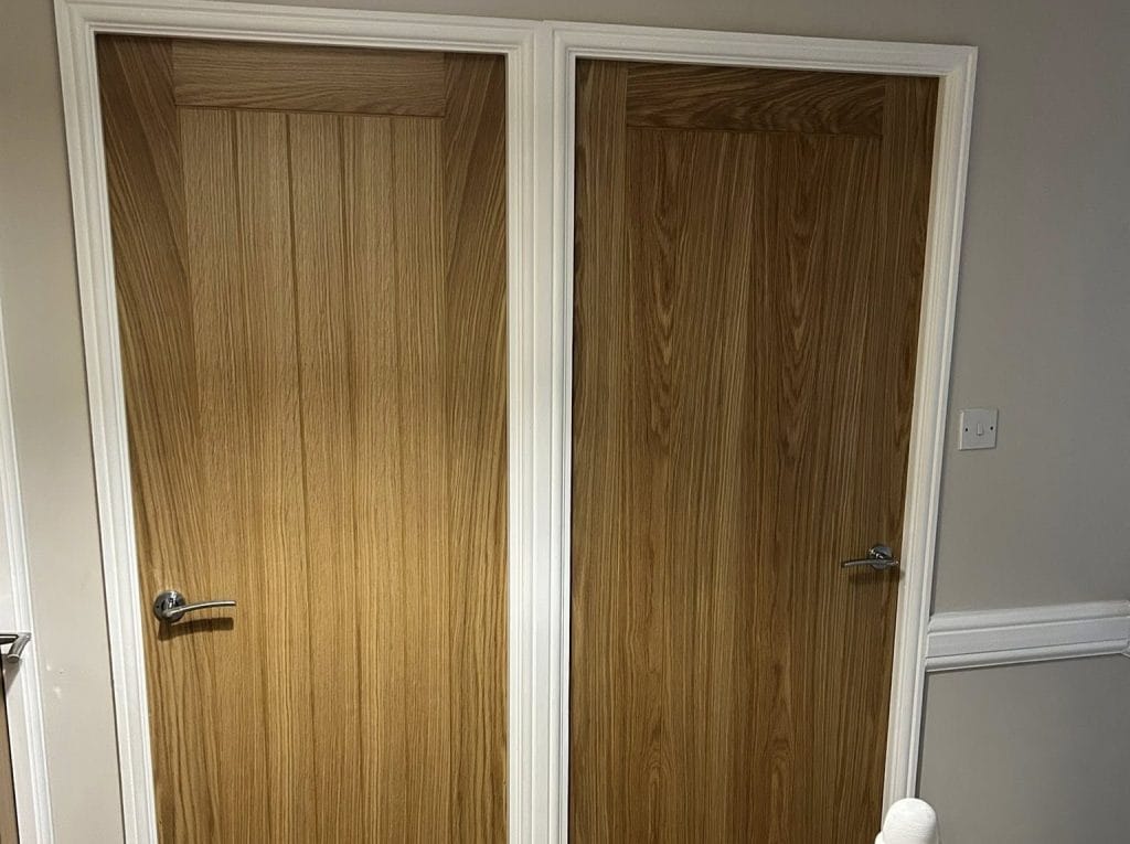 Two oak veneer interior doors Pontefract with chrome lever handles in white architrave frames